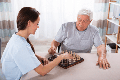nurse playing checkers with elder man